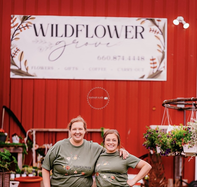 The owners standing in front of Wildflower Grove sign